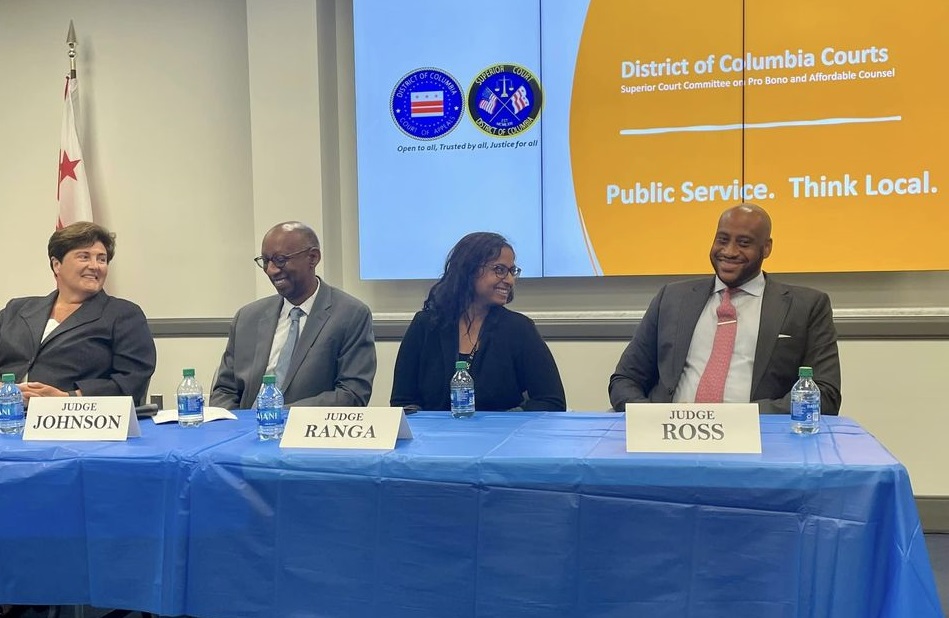 4 judges sitting at the head table in a conference, smiling with each other